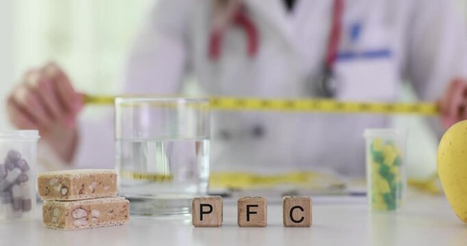 Letters PFC for proteins fats and carbohydrates and nutritionist with tape measure. Doctor consults about healthy eating in hospital office
