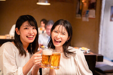 居酒屋で女子会をする二人の女性