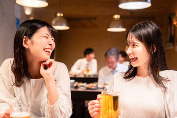 居酒屋で女子会をする二人の女性