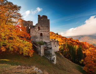 Fototapeta premium Beautiful autumn landscape with ruins of medieval castle on the hill in sunny day.