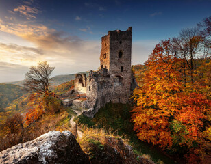 Fototapeta premium Beautiful autumn landscape with ruins of medieval castle in sunny day.