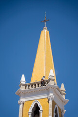 Obraz premium Man working on the steeple on a church in the square in Mazatlan, Mexico