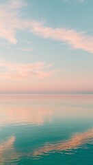 Fototapeta premium serene, peaceful sea, with still, mirror-like, turquoise water reflecting a warm, soft, pastel-hued sky at sunrise or sunset,