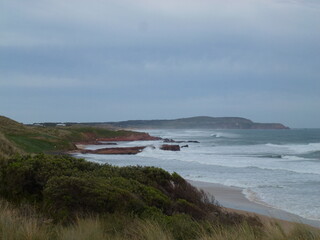 waves crashing along the coastline of Phillip Island, Victoria, over cast day with the ocean and...