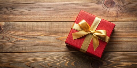 Fototapeta premium A red gift box adorned with a golden ribbon, resting upon a rustic wooden surface, conveying a sentiment of celebration and generosity.