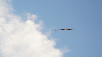 view of the blue sky with mountains and roofs of houses, in the sky there are kites