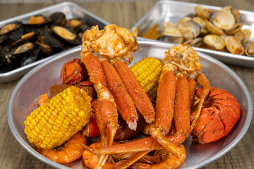 Seafood cajun feast with shellfish choices for dinner with the snow crab legs, lobster, corn, and shrimp up front