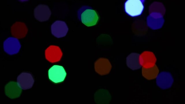 Una toma de cerca de varias luces de colores en forma de c&iacute;rculos en movimiento en la oscuridad. Desenfoque, efecto Bokeh