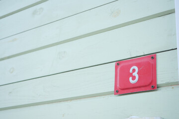 House Number 3 displayed prominently on beautiful Weathered Green Wood Paneling exterior