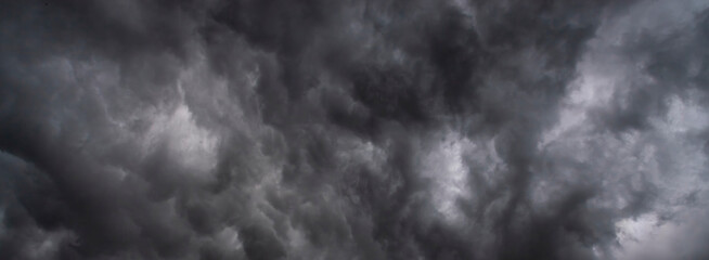 Banner Dramatic dark storm clouds black sky background. Dark thunderstorm clouds rainny season. Panorama Meteorology danger windstorm disasters climate. Dark cloudscape storm cloud with copy space.