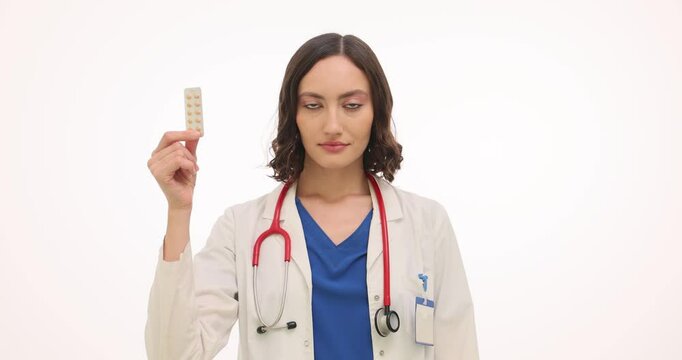 Woman doctor shows blister pack of pills and condoms on white background. Female gynecologist explains contraception options to university student