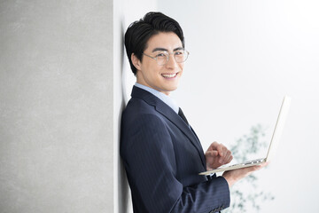 士業や税理士、コンサルタントなどのイメージ　パソコンを持つ　カメラ目線