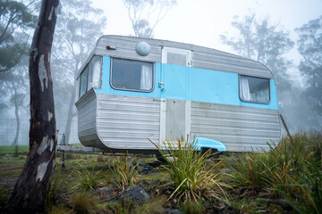 vintage Caravan camping at a campground off grid on a holiday in fog in the forest