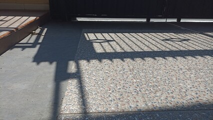 Shadows fence on the floor at sunny summer morning. Sunlight through the fence on the floor surface