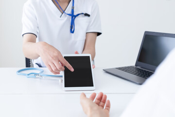 タブレットを操作して説明している医療従事者の女性