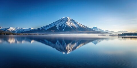 Scenic view of tranquil mountain reflecting on frozen lake during winter