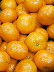 Many mandarines. Many ripe tangerines close-up. Bright background - tangerines. Benefits of citrus fruits.