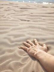 Human hand in the beach sand