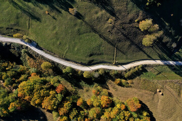 Aerial view of rural dirt village road in autumn
