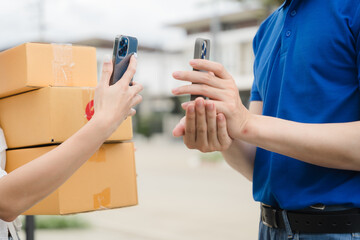 Delivery App: Contactless Delivery: A woman uses her mobile phone to scan a barcode on a delivery...