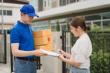 Delivery Confirmation: A smiling delivery man hands a package to a customer while she signs for the...