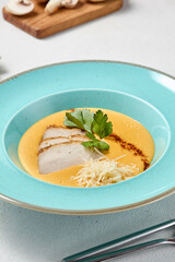 Elegant Pumpkin Cream Soup with Chicken and Parmesan in Soft Pastel Setting