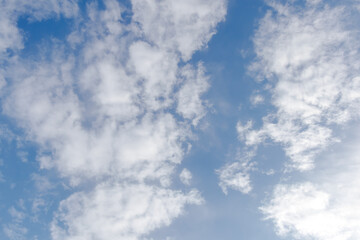 Blue sky with fluffy white clouds on a sunny summer day. Soft fluffy clouds in the blue sky.