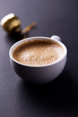 Cup of coffee on dark paper background. Soft focus. Close up. Copy space.