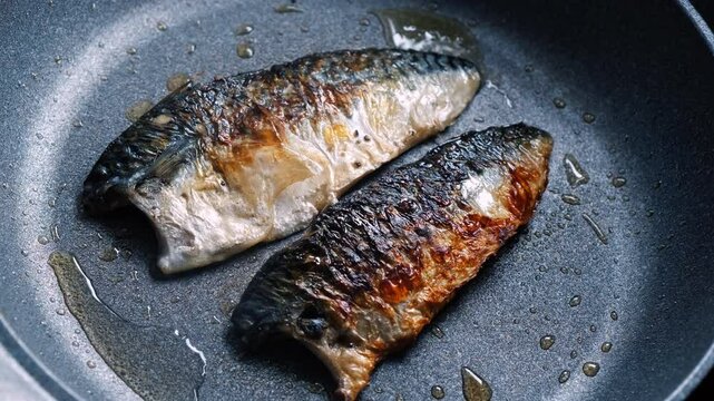 Cooking mackerel fish in a frying pan. A cook fries capelin in a restaurant kitchen before dinner. 