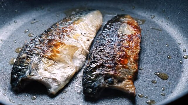 Cooking mackerel fish in a frying pan. A cook fries capelin in a restaurant kitchen before dinner. 