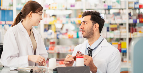 Pharmacists counting drug pills arranging assortment working in drug shelves counter