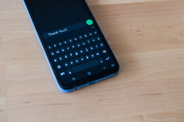 Smartphone On A Wooden Background Showing A Thank You Message