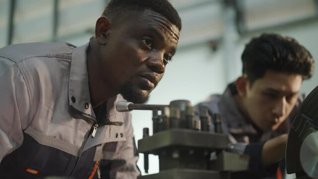 Blue collar workers upskill at lathe machine shop. Factory and Industry.