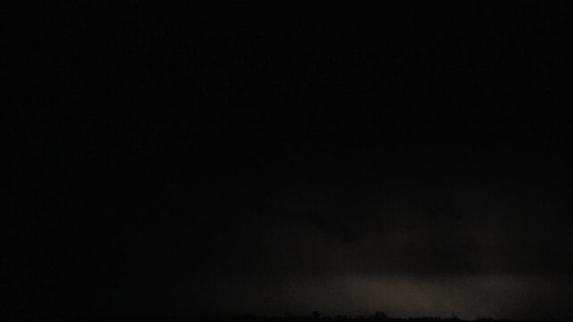 Fast moving clouds during heavy thunderstorm, lighting up the sky with lightning strikes.