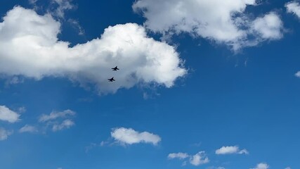 Two formations of blue angel f18 hornet jets fly by over ocean clouds