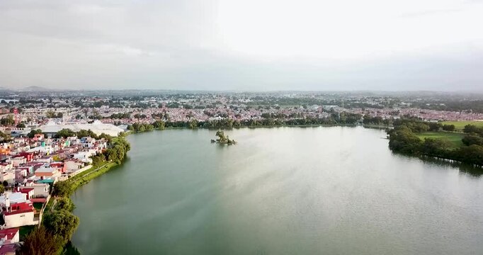 Panoramic aerial shot of Axotl&aacute;n Lagoon in Cuautitl&aacute;n Izcalli, State of Mexico, featuring an artificial islet in the middle, serving as a habitat for local wildlife