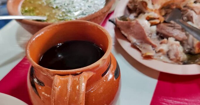 Shot of a traditional Mexican family breakfast, featuring Mexican pot coffee, lamb barbacoa wrapped in maguey leaves, consomm&eacute;, and handmade tortillas