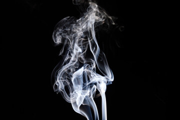 Obraz premium Mysterious wisps of smoke dance gracefully against a dark background at twilight