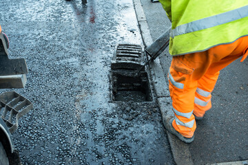 Early morning reveals workers diligently cleaning road drainage system to prevent flooding
