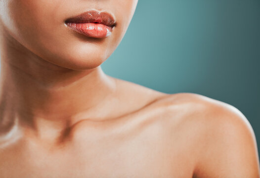 Beauty, collarbone and dermatology with woman in studio isolated on blue background for hygiene closeup. Body, skincare and lips with glow, model person at salon or spa for natural cosmetic treatment