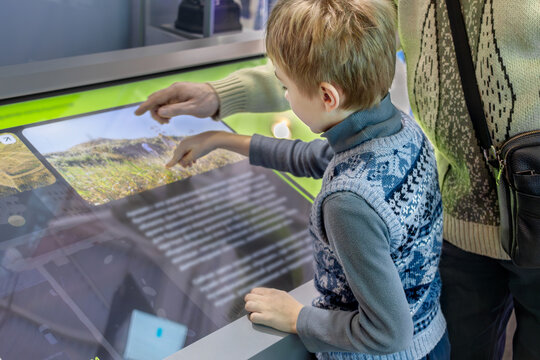Father and Son Exploring Technology Together on Interactive Screen