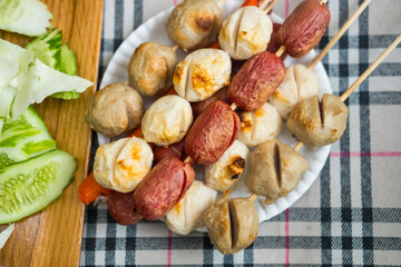 Asian Thai food grilled meatballs fishball and porkball, Meatballs and sausage on skewers in white plate