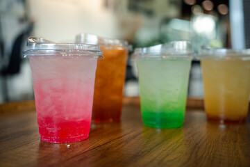 Italian soda made from fruit syrup drink mix in plastic cup on table