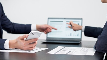 ミーティングでスマホを使うビジネスマンの手元
