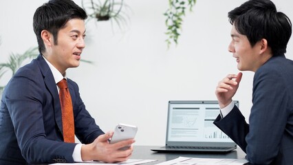 ミーティングでスマホを使うビジネスマン