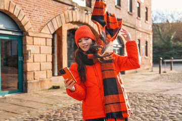 A joyful moment captured on a sunny winter day in a vibrant red outfit with a stylish scarf and...
