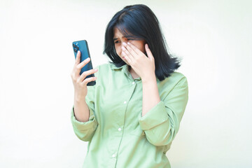 sad asian woman wipes her tears after cry for using social media on smartphone hold on hands...