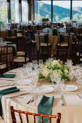 Beautifully arranged tables set for a stunning wedding reception, adorned with exquisite floral centerpieces and breathtaking views of the mountains, creating a perfect atmosphere for celebration