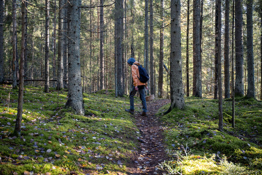 man in an yellow jacket with a backpack walking in the autumn forest