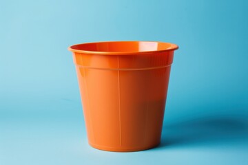 Bright orange plastic pot on a blue background